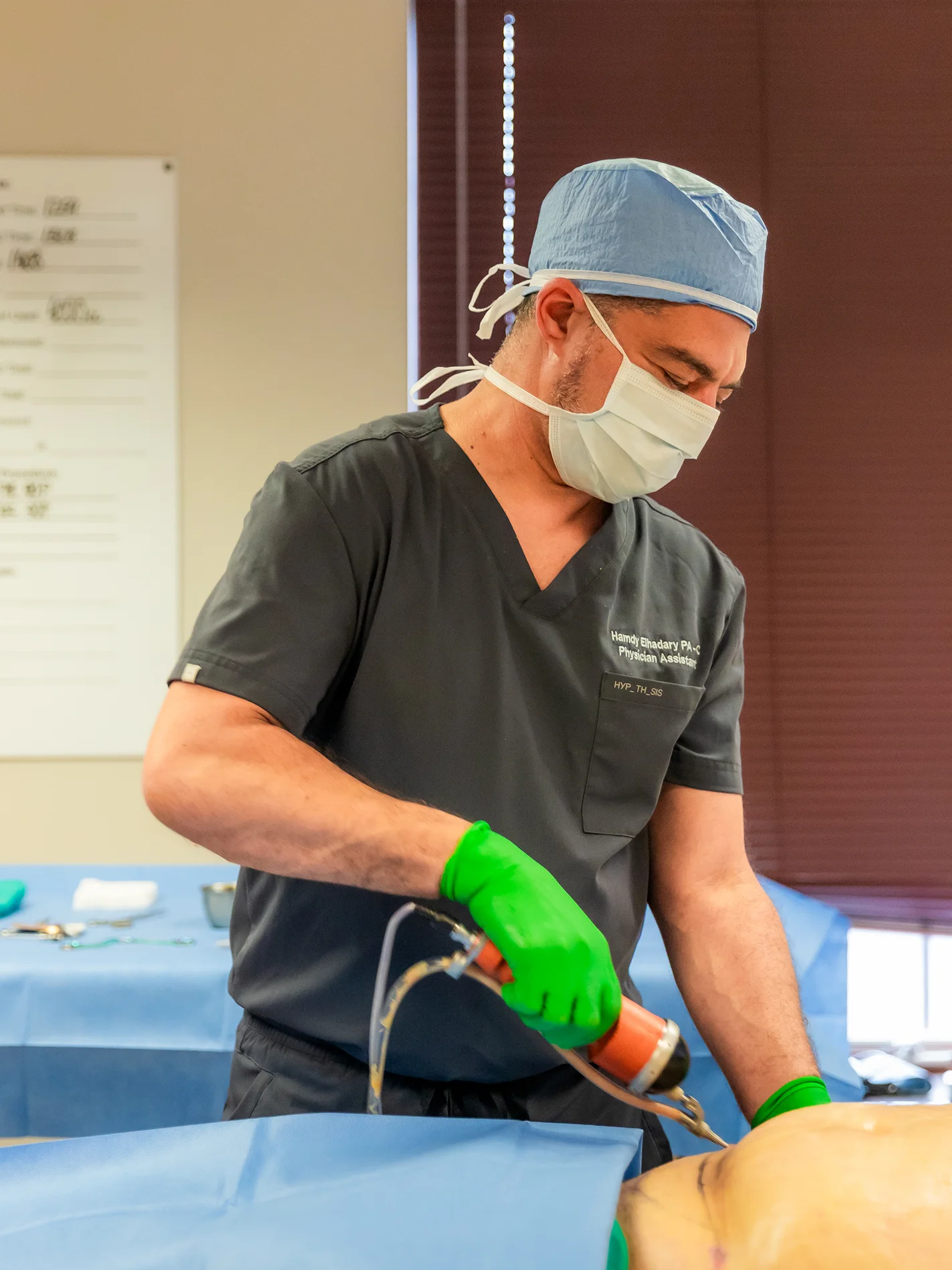 Hamdy Elhadary PA-C injecting a medical decive into patients lower stomach. - Doctor in Brookfield and Appleton, WI.