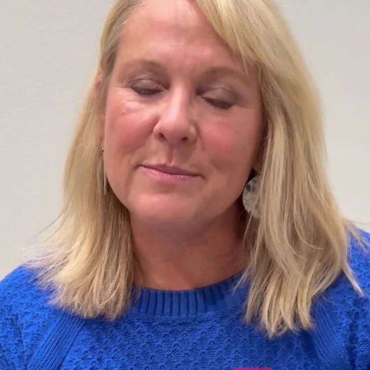 Woman with blonde hair wearing blue sweater sharing healthcare experience