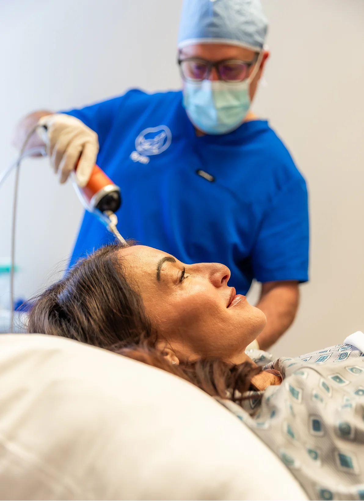 Female patient receiving PRF treatment from medical professional in blue scrubs and protective gear - in Brookfield and Appleton, WI.