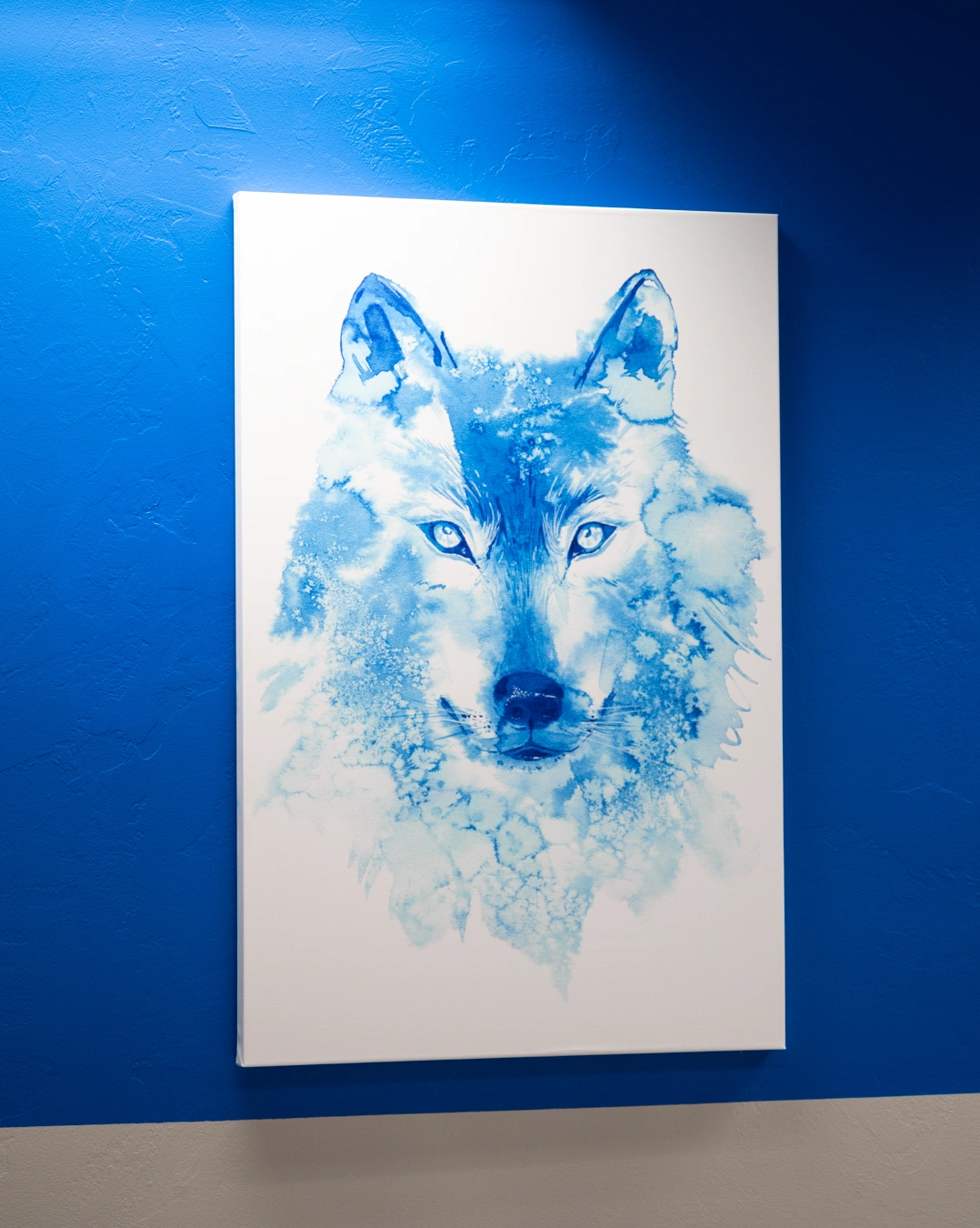 Blue watercolor wolf artwork displayed on canvas against gradient blue background - In Appleton, Brookfield, Milwaukee, WI & Gurnee, IL
