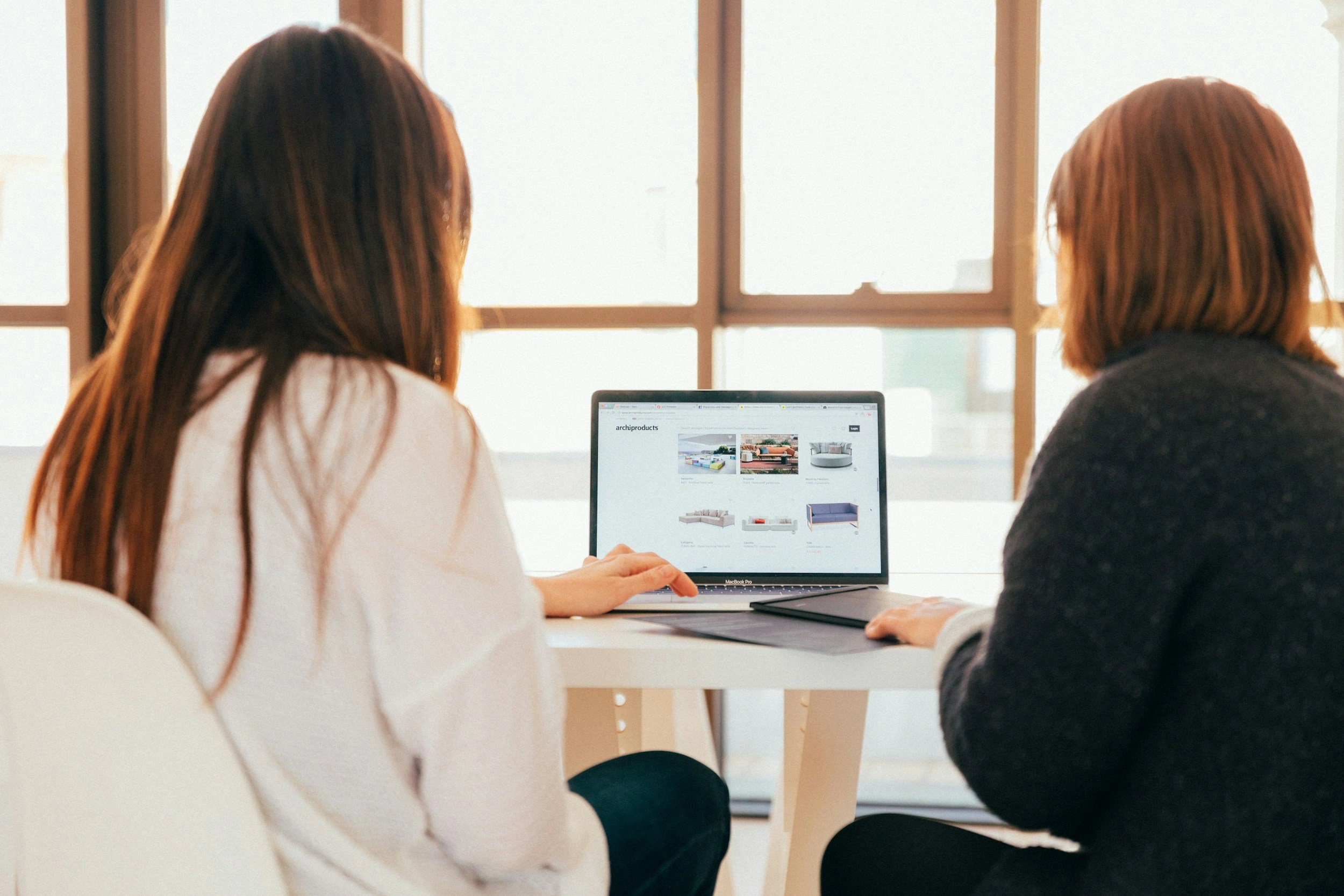 Two women reviewing website content on laptop computer in bright office setting - In Appleton, Brookfield, Milwaukee, WI & Gurnee, IL