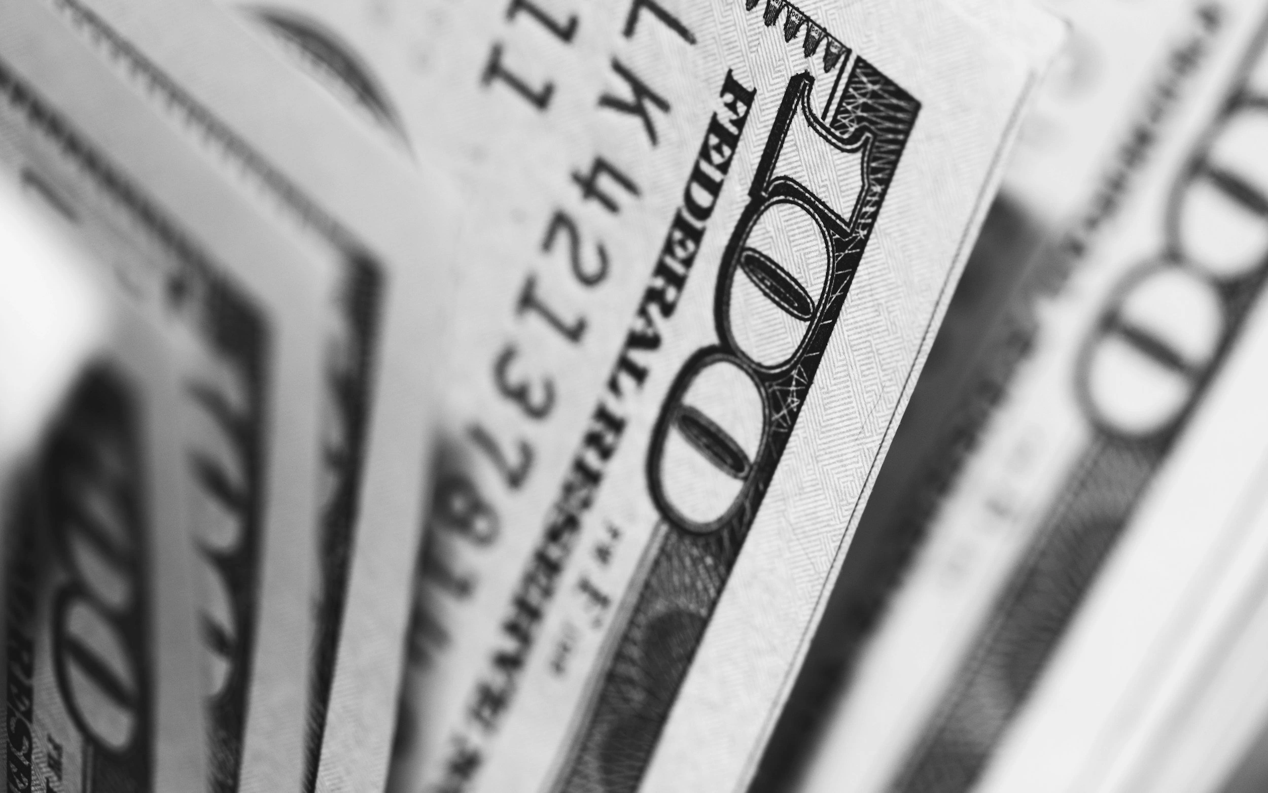 Stack of hundred dollar bills fanned out showing Benjamin Franklin portraits and currency details