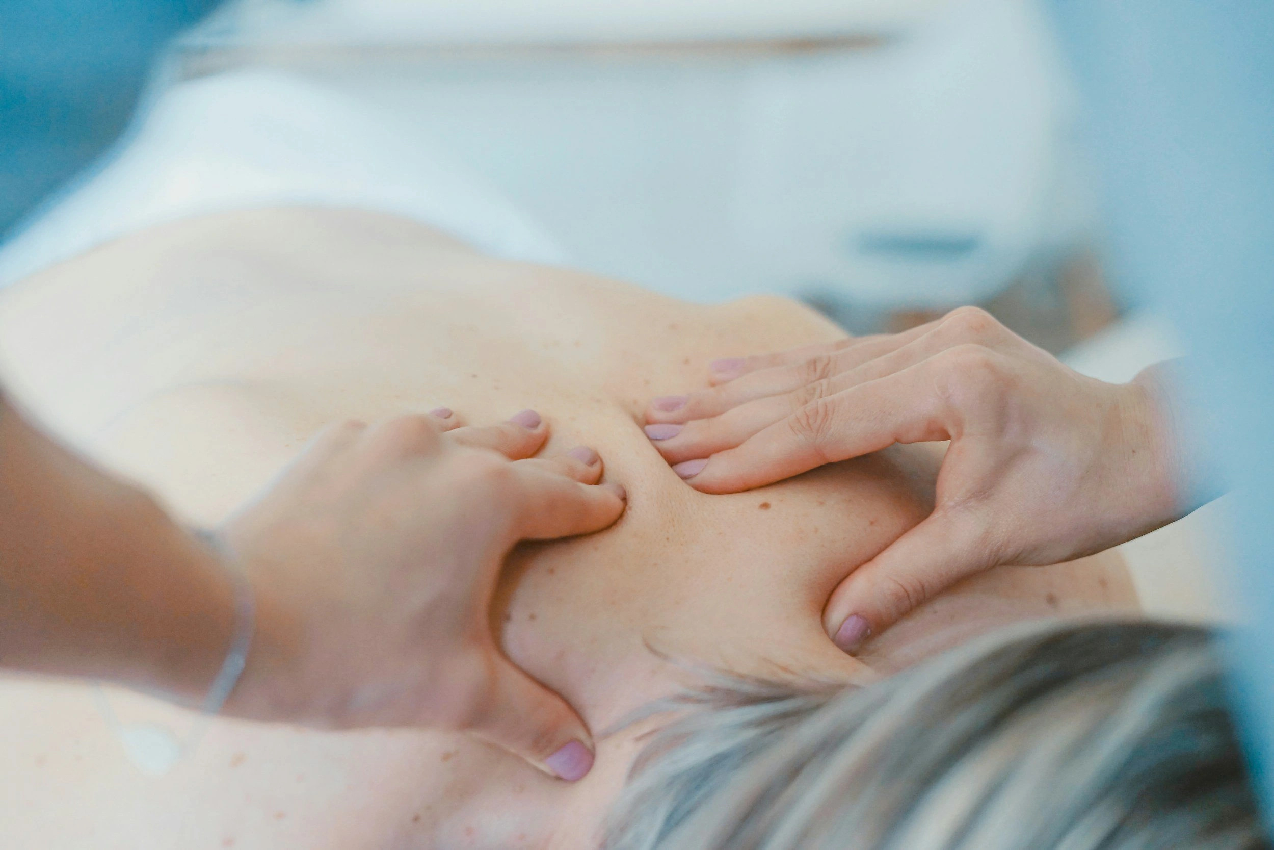 Massage therapist performing shoulder and neck therapy treatment on client during spa tour - In Appleton, Brookfield, Milwaukee, WI & Gurnee, IL